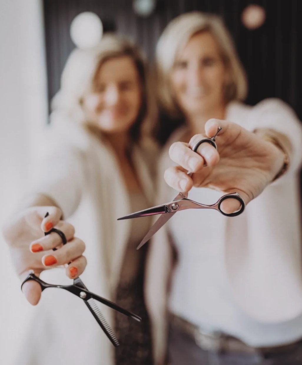 Britta und Nadine halten ihre Friseurscheren in die Kamera.